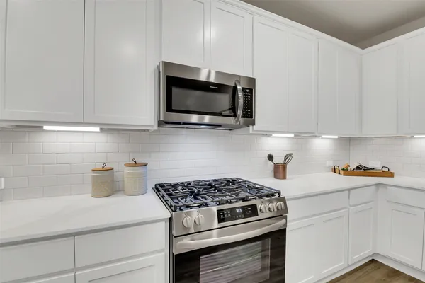 a kitchen with stainless steel appliances a stove a microwave and cabinets