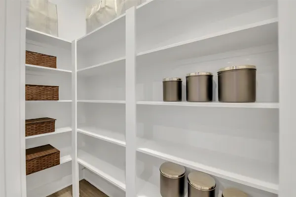 a kitchen with stainless steel appliances a stove a sink a refrigerator white cabinets and wooden floor