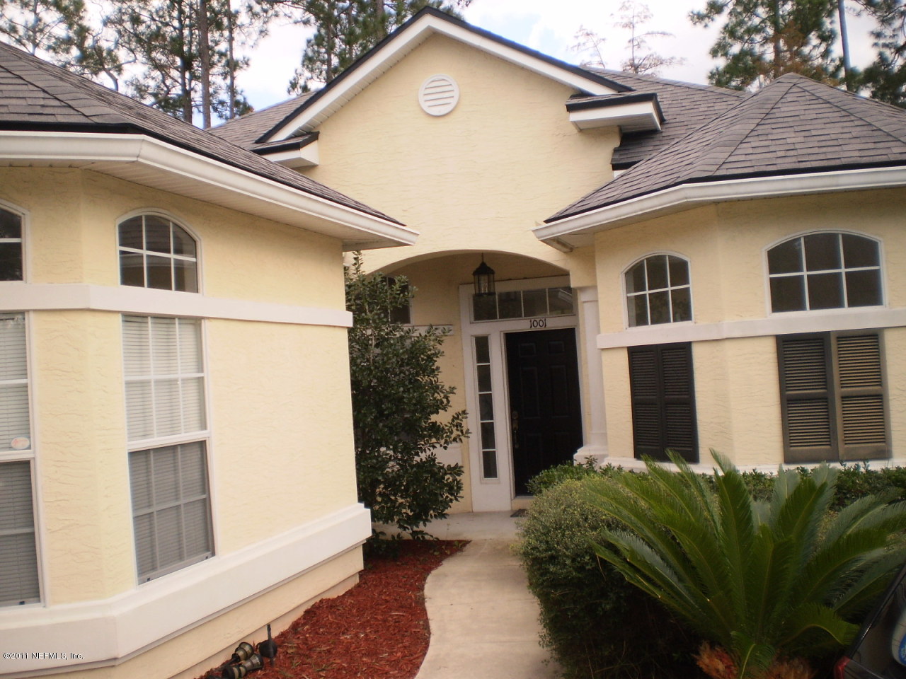 a front view of a house with a garden
