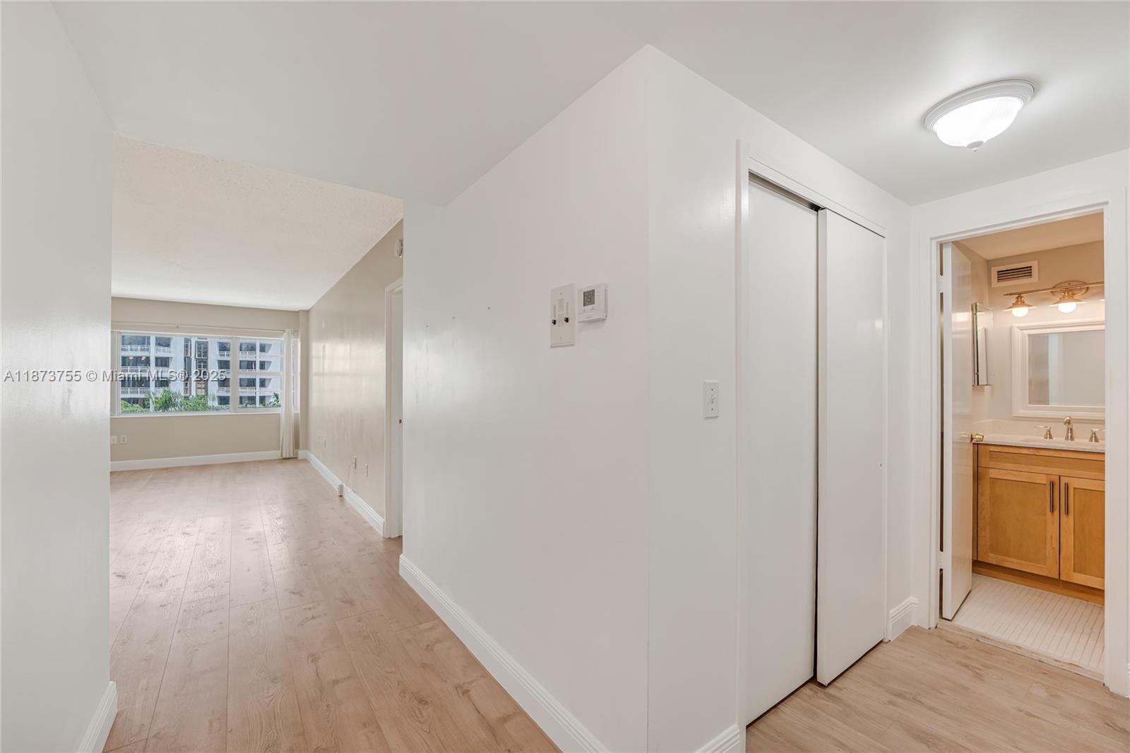 1700 Northeast 105th Street, Unit 505 Miami Shores, FL 33138 - Photo 19 of 20 a view of hallway with an empty room and wooden floor