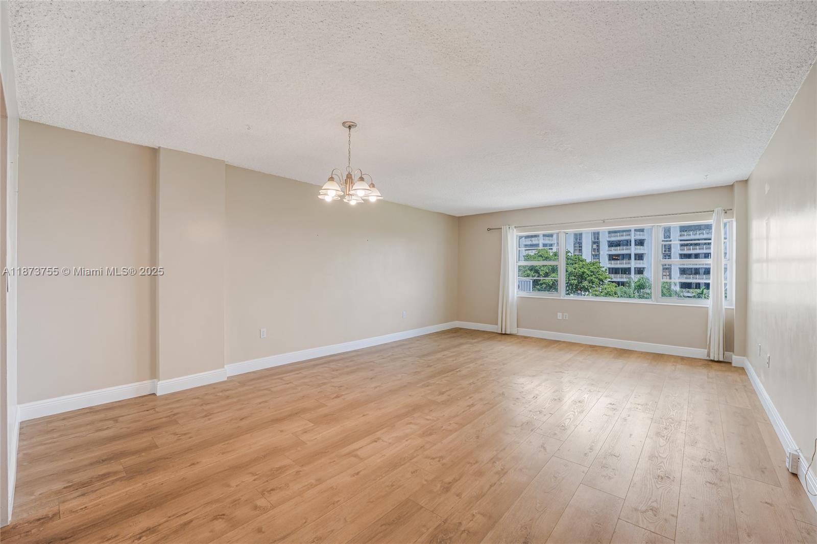 1700 Northeast 105th Street, Unit 505 Miami Shores, FL 33138 - Photo 3 of 20 wooden floor in an empty room with a window