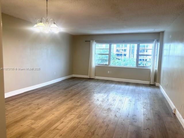 1700 Northeast 105th Street, Unit 505 Miami Shores, FL 33138 - Photo 5 of 20 an empty room with wooden floor and windows