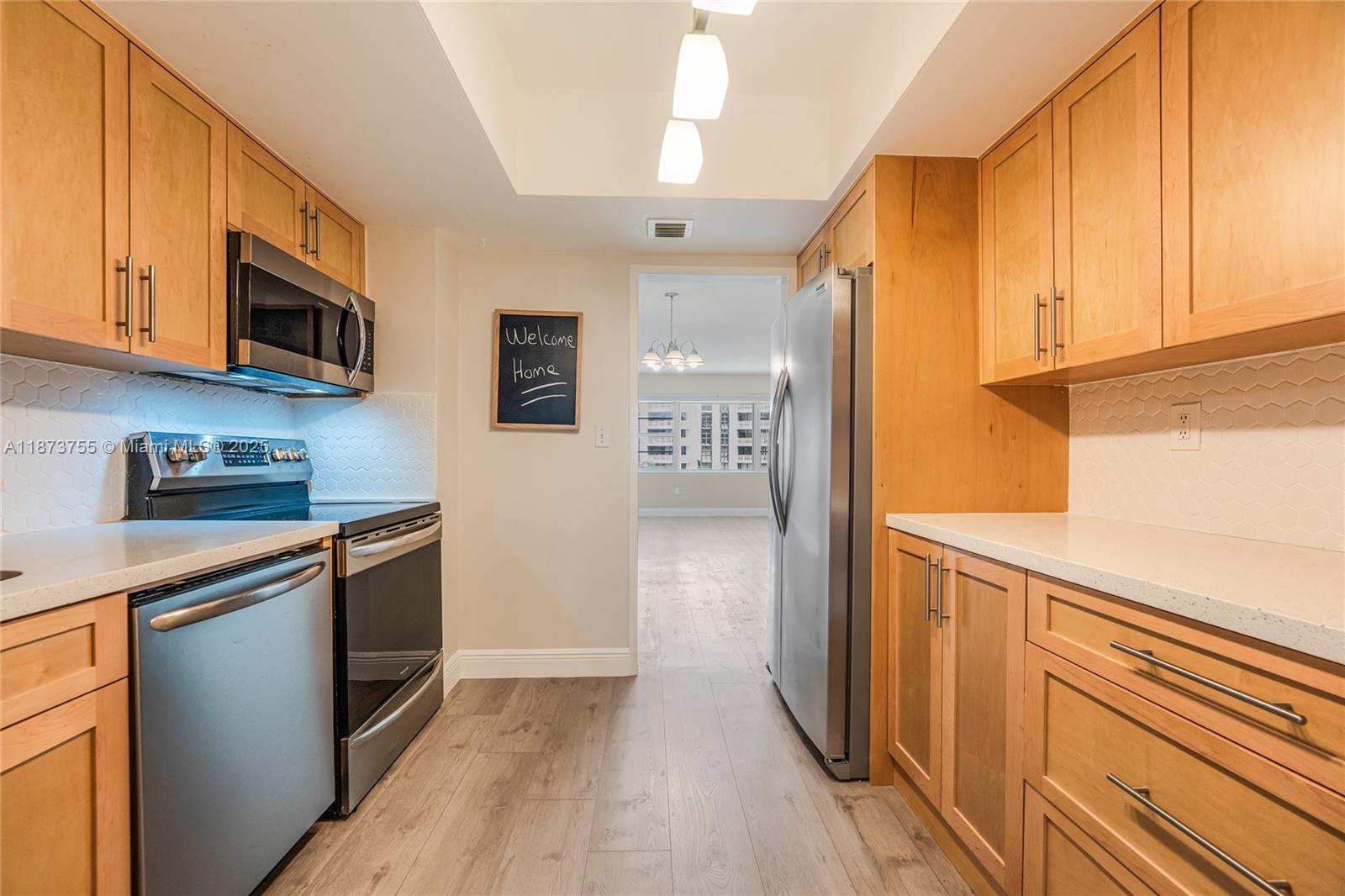 1700 Northeast 105th Street, Unit 505 Miami Shores, FL 33138 - Photo 9 of 20 a kitchen with stainless steel appliances granite countertop a refrigerator and a sink