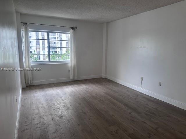 1700 Northeast 105th Street, Unit 505 Miami Shores, FL 33138 - Photo 10 of 20 an empty room with wooden floor and windows
