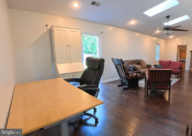 a view of a backyard with plants and large tree