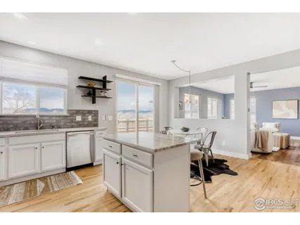 a open kitchen with granite countertop a sink cabinets and wooden floor