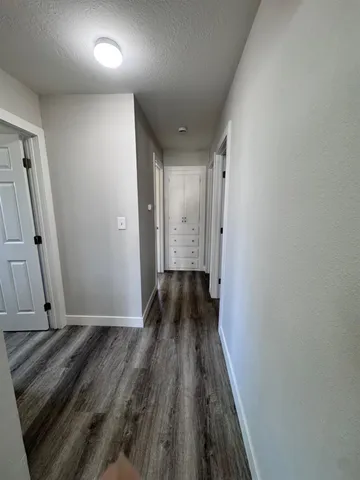 a view of a hallway with wooden floor