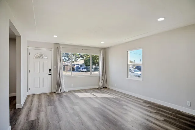 a view of a big room with wooden floor and windows