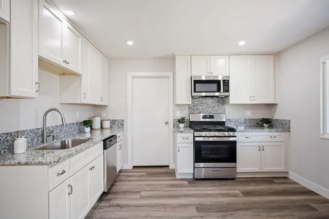 a kitchen with stainless steel appliances granite countertop a stove sink and cabinets
