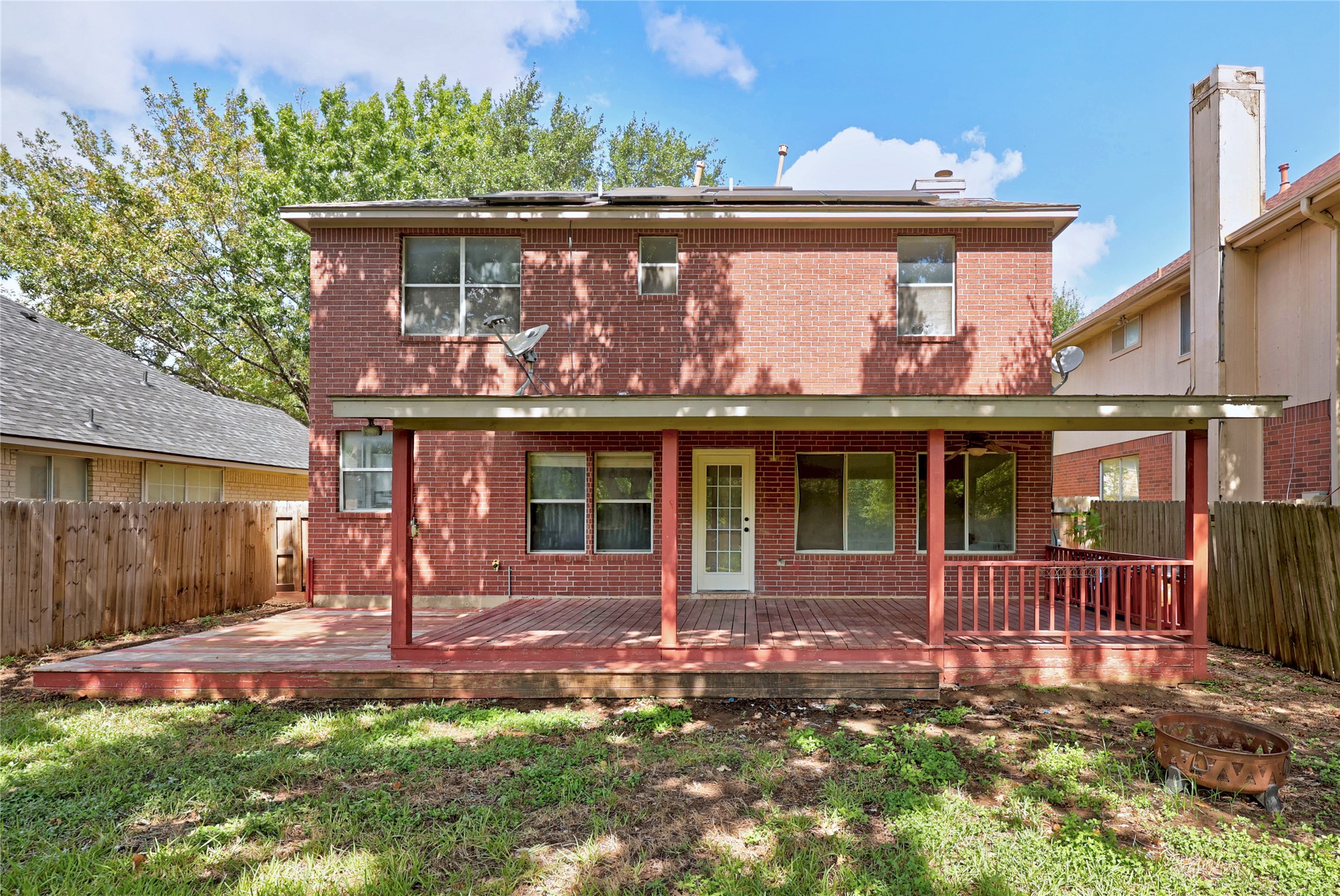 13217 Rochester Lane Austin, TX 78753 - Photo 27 of 30 A spacious wooden deck extends from the rear brick facade beneath a covered porch.