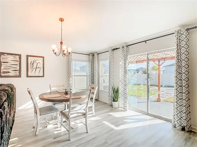 a view of a dining room with furniture wooden floor and chandelier