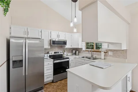 a kitchen with stainless steel appliances kitchen island a refrigerator sink and stove