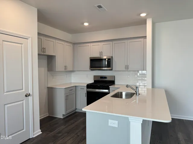 a kitchen with a sink a stove a microwave and refrigerator