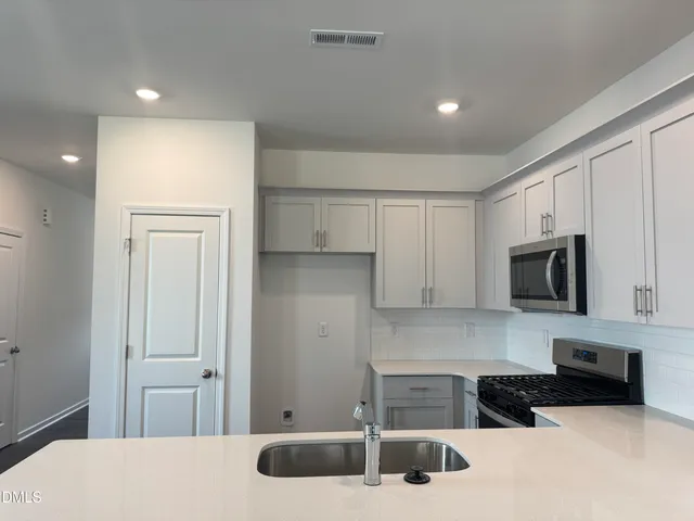 a kitchen with a sink a microwave and cabinets