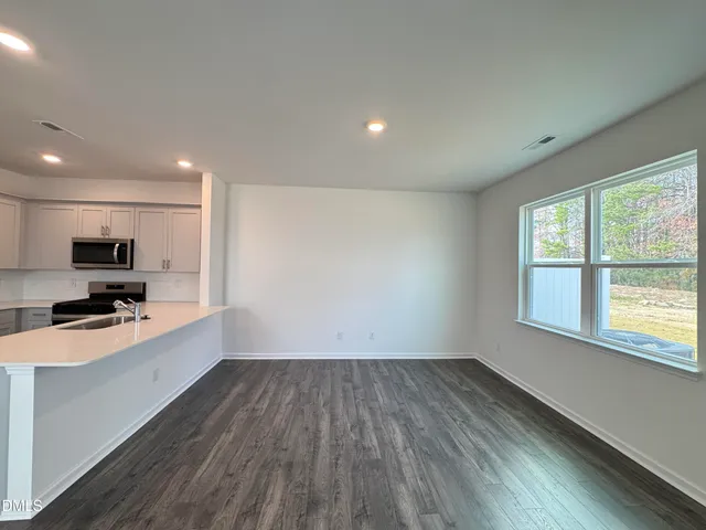 a view of a kitchen with a sink wooden floor and a window