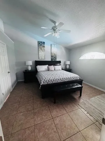 a bedroom with a bed and ceiling fan