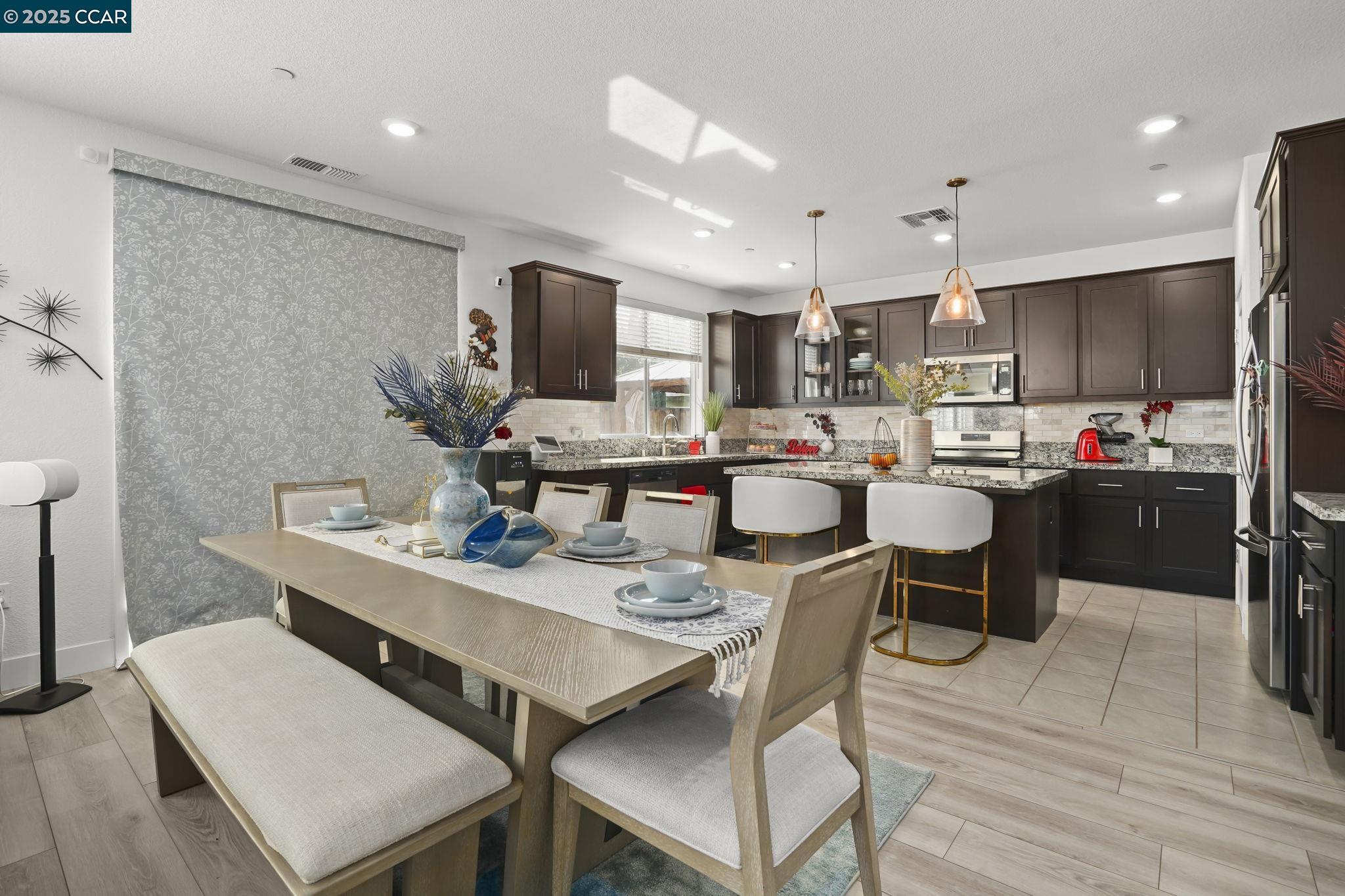 433 Ramos Ranch Road Oakley, CA 94561 - Photo 7 of 25 a dining room with stainless steel appliances kitchen island granite countertop a dining table chairs and a refrigerator