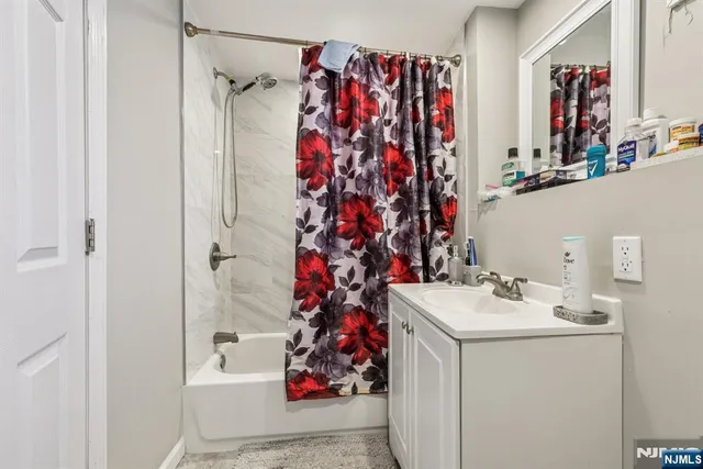 a bathroom with a sink vanity mirror and shower curtain