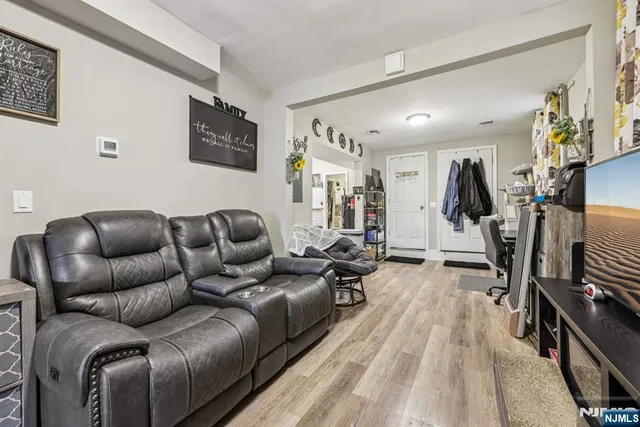 a living room with furniture a flat screen tv and a wooden floor