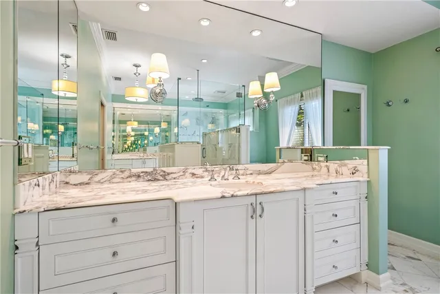 a bedroom with a bed a chandelier and a large window