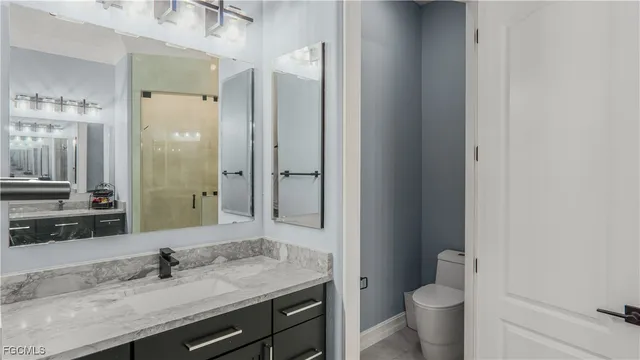 a bathroom with a granite countertop sink toilet and shower