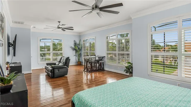 a living room with furniture large window and wooden floor