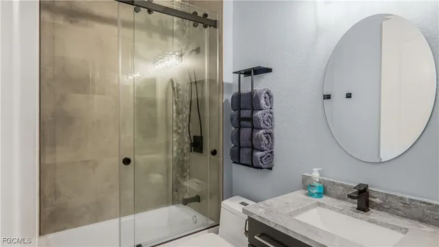 a bathroom with a granite countertop sink a mirror and shower