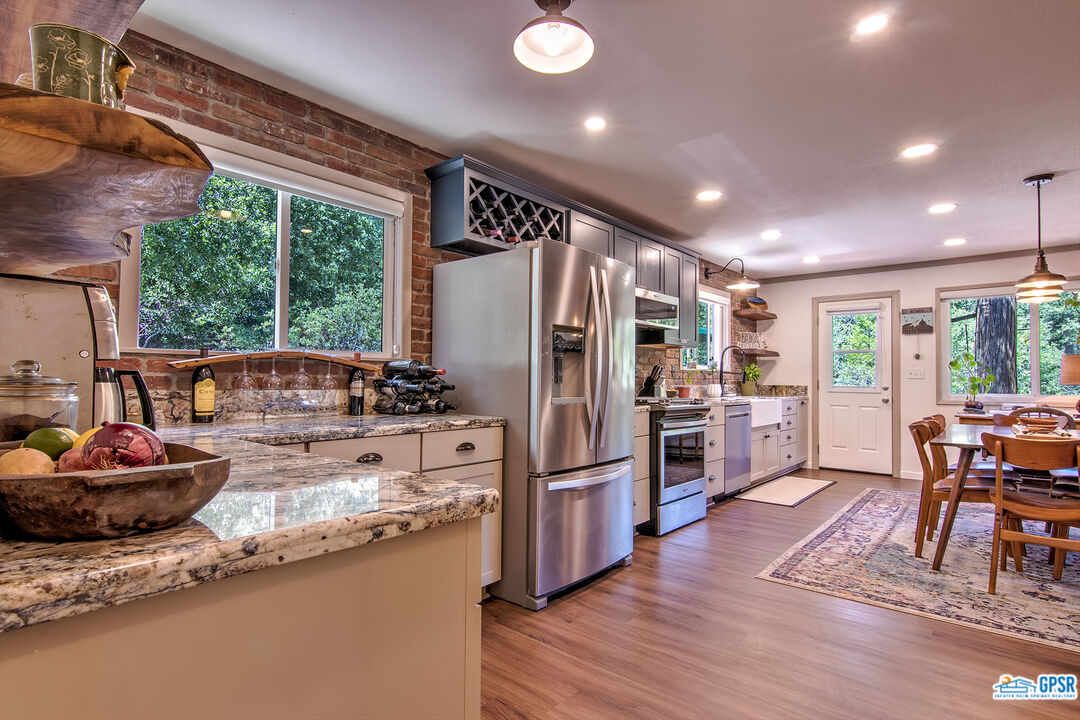 25527 Cedar Glen Drive Idyllwild, CA 92549 - Photo 13 of 69 a kitchen with stainless steel appliances granite countertop a refrigerator a stove and a wooden floors