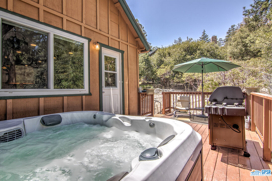 25527 Cedar Glen Drive Idyllwild, CA 92549 - Photo 15 of 69 a view of a patio with a table and chairs under an umbrella with wooden fence