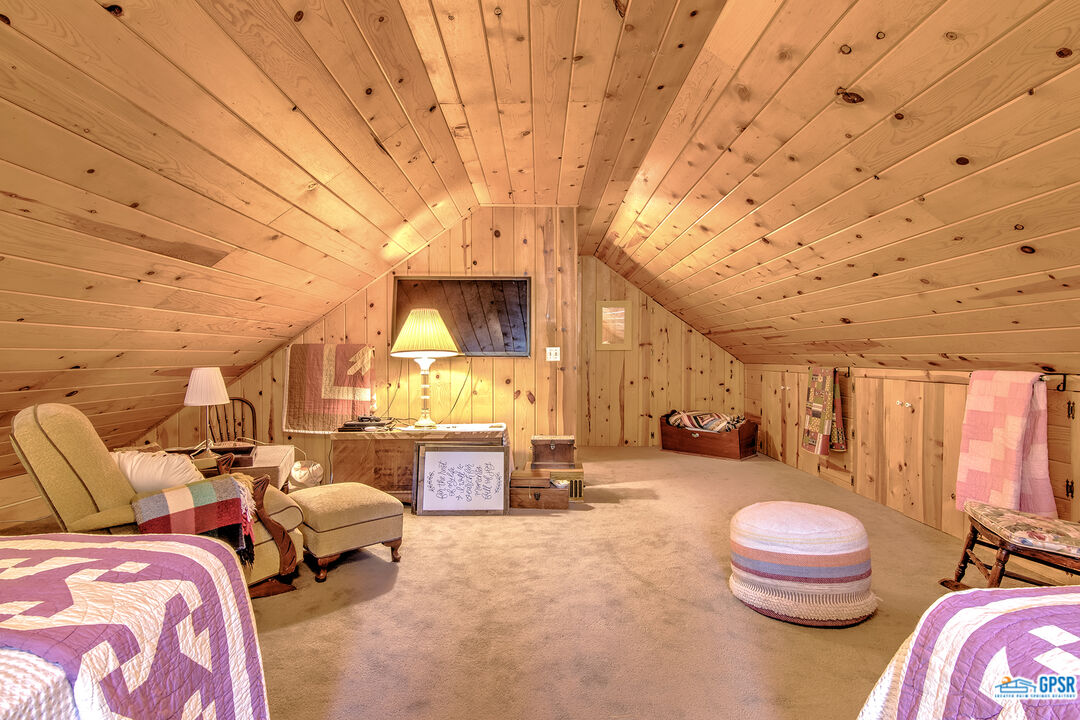 25527 Cedar Glen Drive Idyllwild, CA 92549 - Photo 23 of 69 a spacious bedroom with a bed and a chandelier