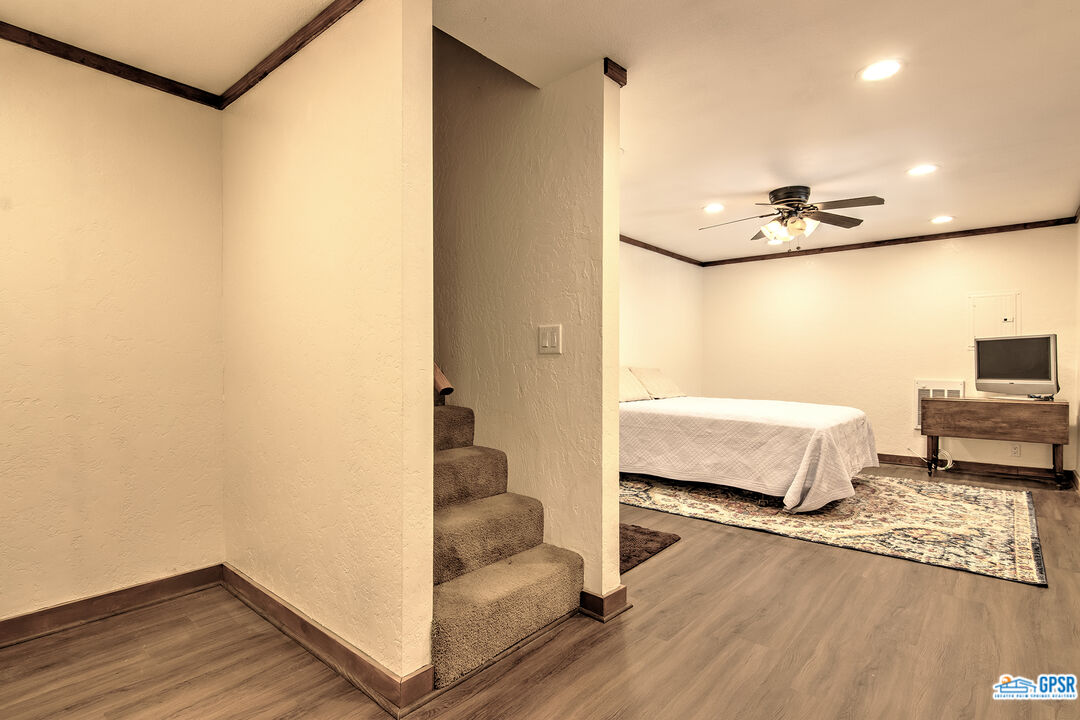 25527 Cedar Glen Drive Idyllwild, CA 92549 - Photo 29 of 69 a bedroom with a bed and a table with wooden floor