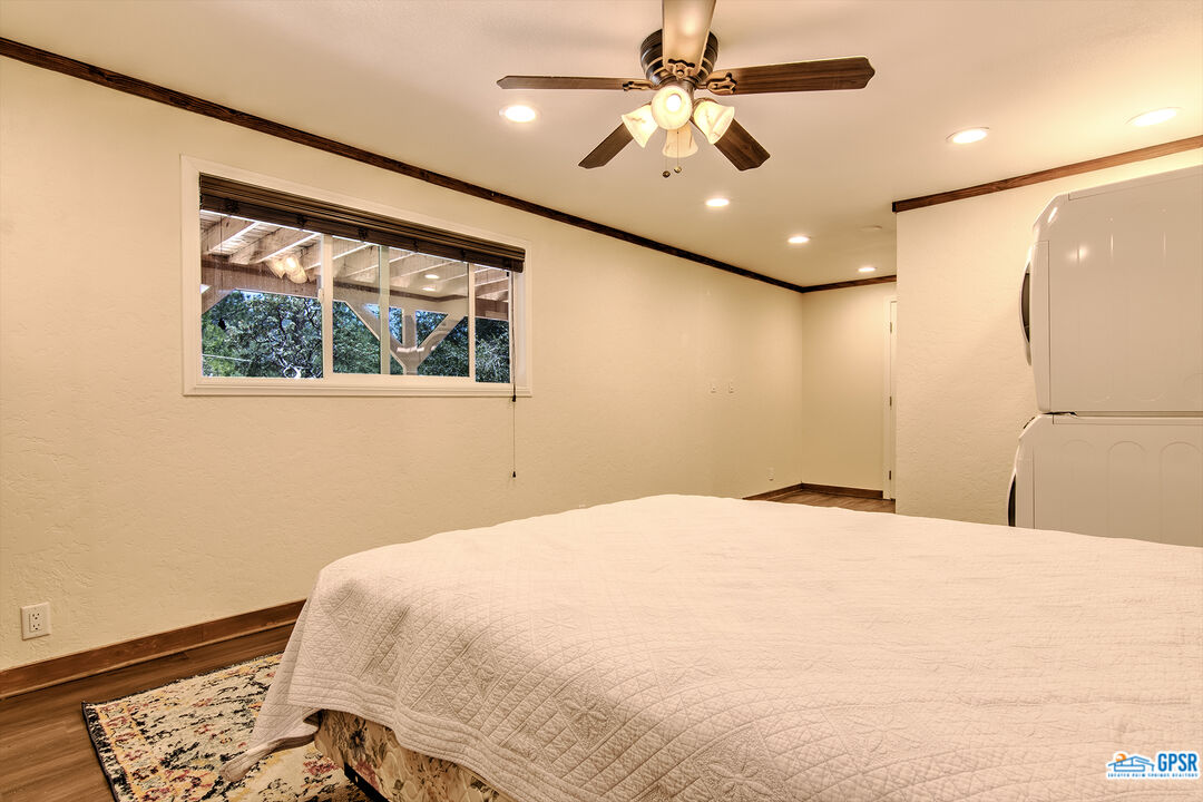 25527 Cedar Glen Drive Idyllwild, CA 92549 - Photo 30 of 69 a bedroom with a large bed and a chandelier