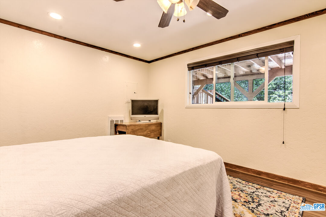 25527 Cedar Glen Drive Idyllwild, CA 92549 - Photo 31 of 69 a bedroom with a bed and a flat tv screen on the dresser