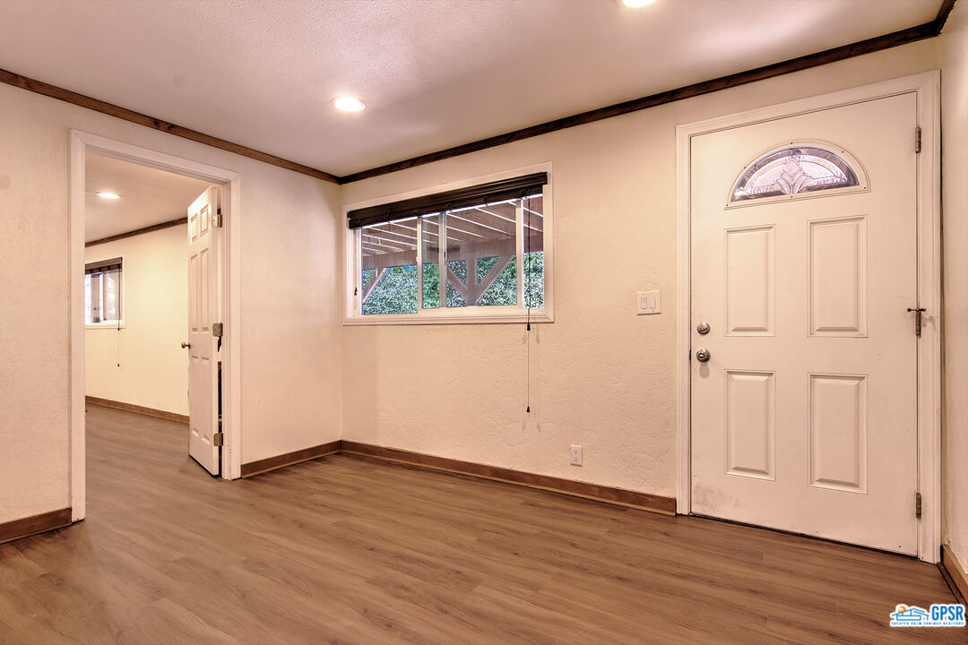 25527 Cedar Glen Drive Idyllwild, CA 92549 - Photo 32 of 69 an empty room with wooden floor and windows