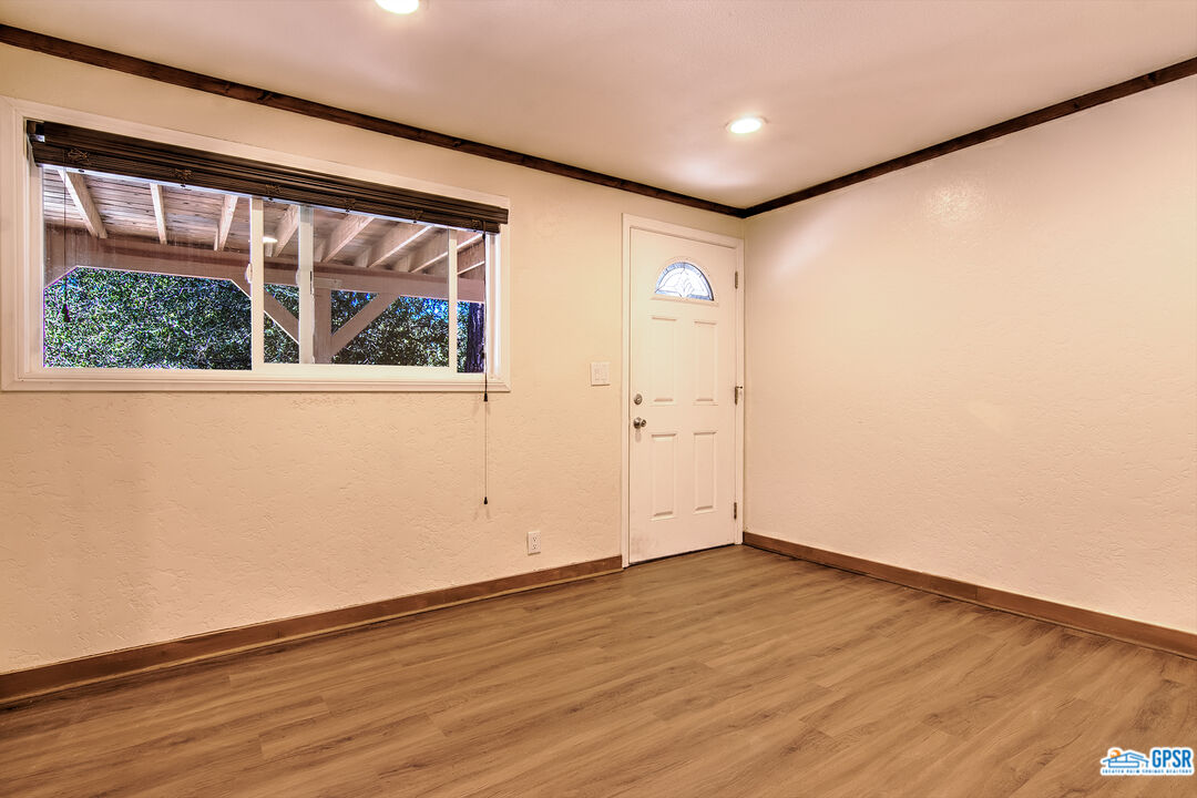25527 Cedar Glen Drive Idyllwild, CA 92549 - Photo 33 of 69 an empty room with wooden floor and windows