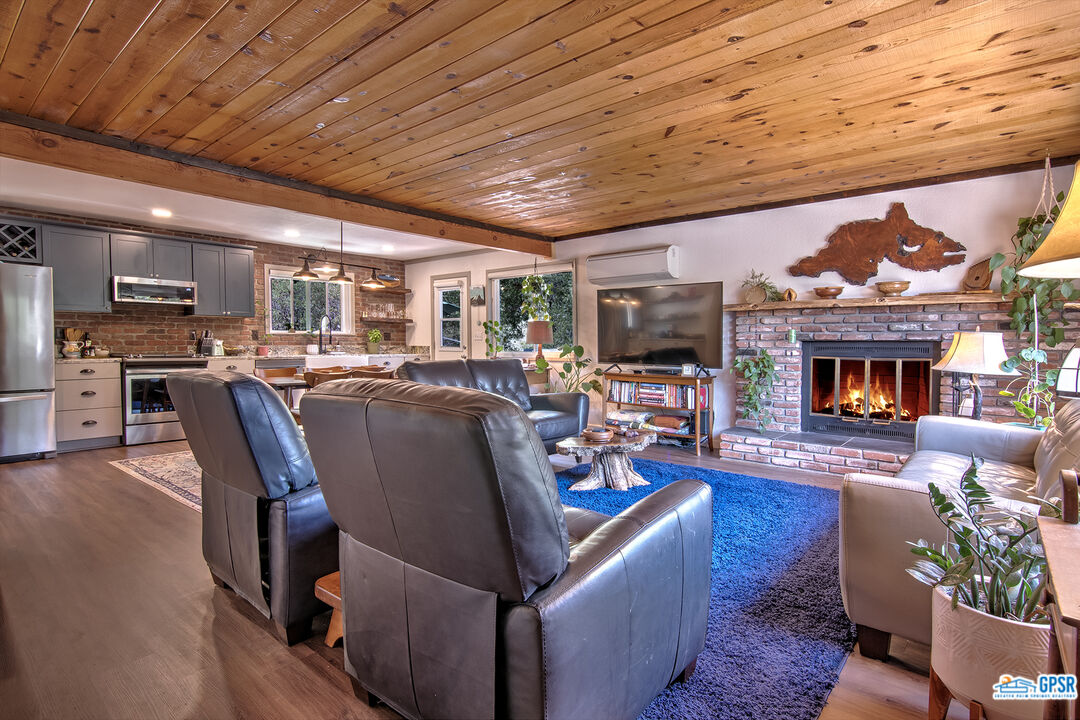 25527 Cedar Glen Drive Idyllwild, CA 92549 - Photo 49 of 69 a living room with furniture wooden floor and a fireplace