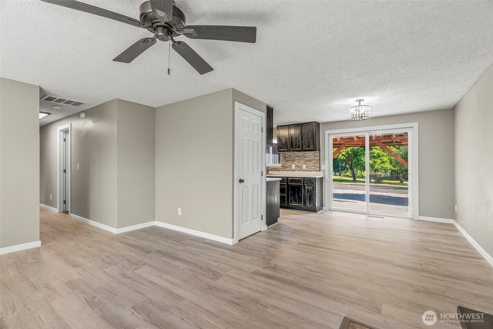 202 Waters Road Castle Rock, WA 98611 - Photo 5 of 38 a view of a kitchen with a microwave and a ceiling fan