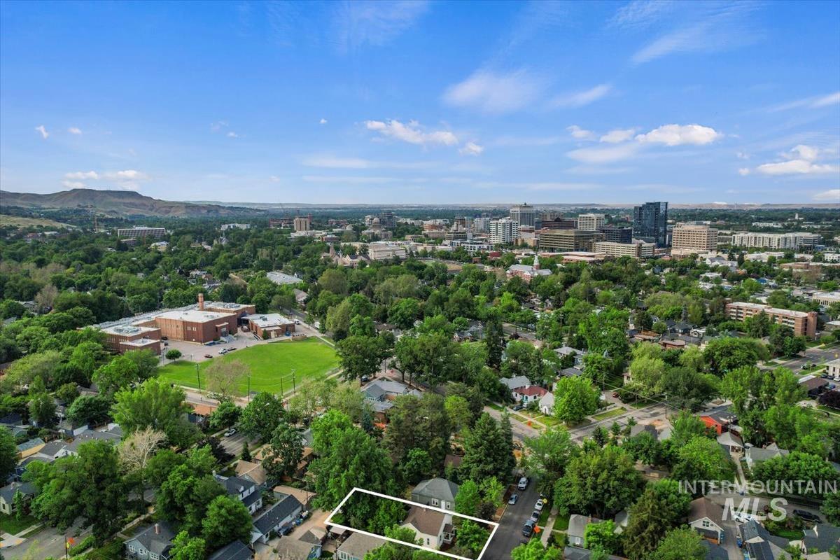 910 North 16th Street Boise, ID 83702 - Photo 45 of 47 Aerial perspective showcasing the property's setting amidst mature trees, residential streets, and distant city skyline