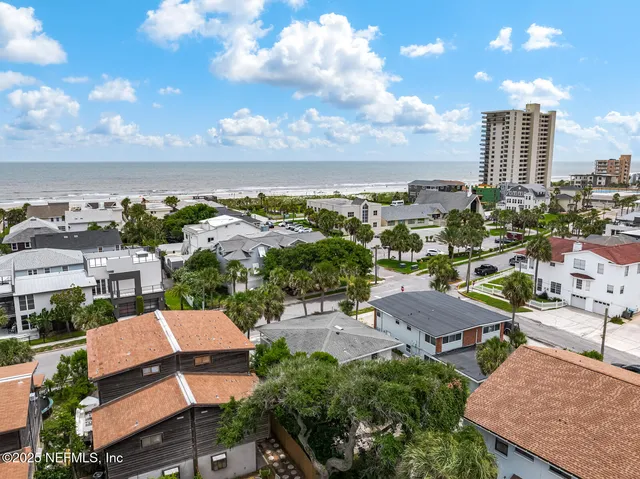 an aerial view of residential houses with outdoor space and a lake view
