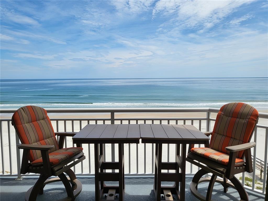 a view of a chairs and table in the balcony