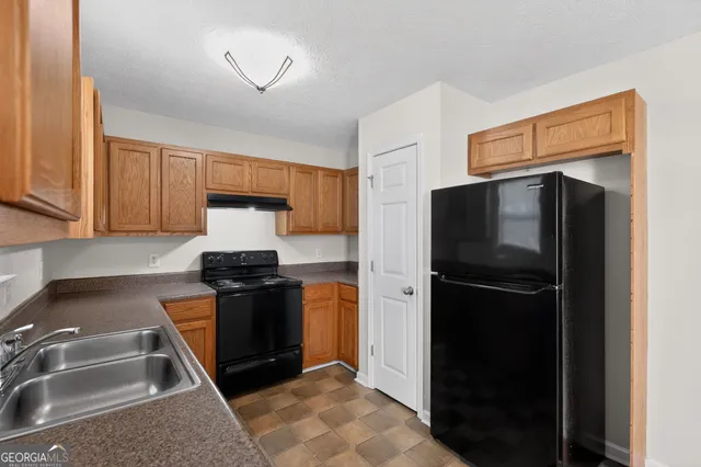 a kitchen with stainless steel appliances granite countertop a refrigerator and a sink