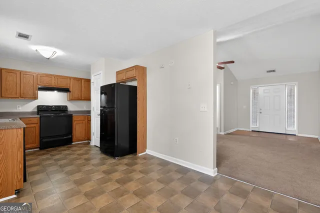 a view of kitchen with refrigerator stove microwave and cabinets