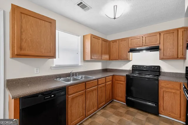 a kitchen with stainless steel appliances granite countertop a sink stove and cabinets