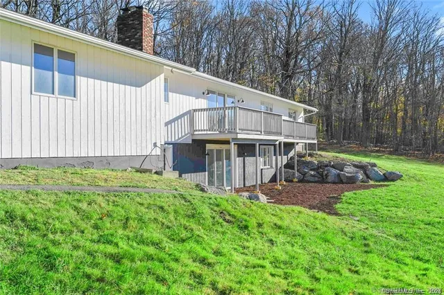 a view of a house with a yard and sitting area