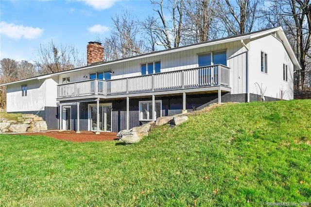 a view of a house with a yard and sitting area