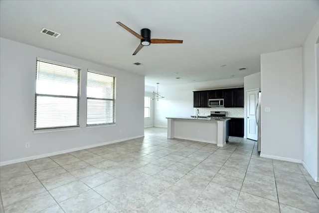 a view of an empty room with a fireplace and a window