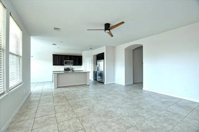 a large white kitchen with a stove a sink and a microwave