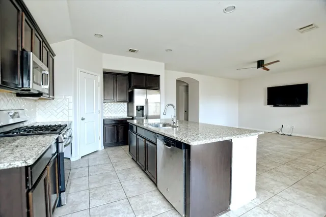 a kitchen with stainless steel appliances granite countertop a sink stove and refrigerator