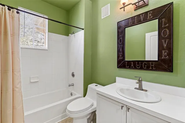a bathroom with a sink vanity mirror toilet and bathtub
