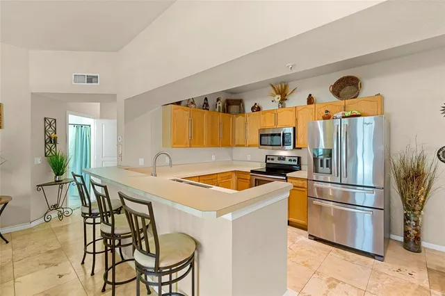 a kitchen with stainless steel appliances granite countertop a sink and a refrigerator